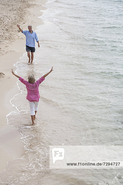 Spain  Seniors couple walking along beach