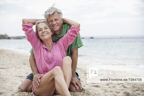 Spain  Seniors couple sitting on beach