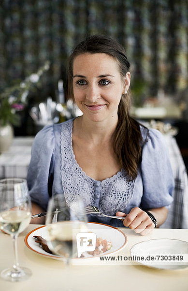Junge Frau am Restauranttisch sitzend
