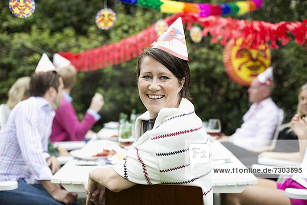 Porträt einer glücklichen Frau  die mit Freunden im Hintergrund Krebspartys feiert.