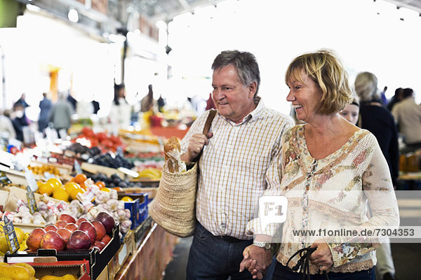 Happy couple looking at fruits in market