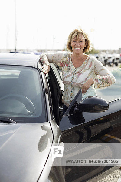 Portrait of mature woman standing by car