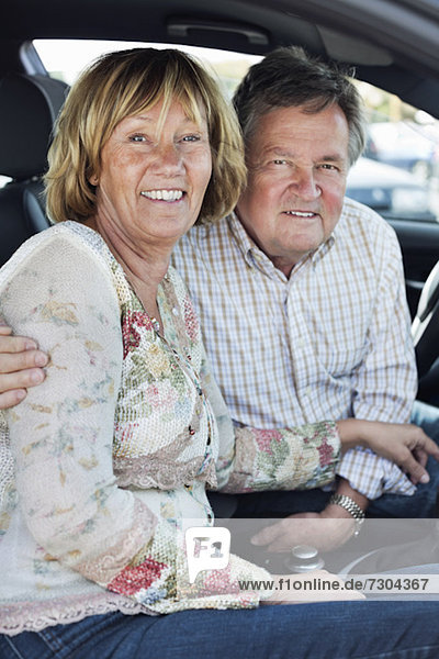 Porträt des glücklichen Paares im Auto sitzend