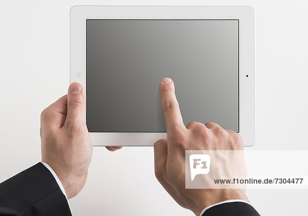 Männerhand zeigt auf Tablet-PC