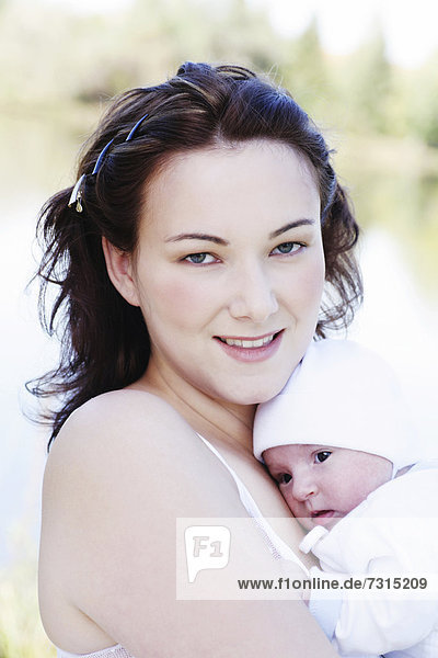 Young mother  22 years  with daughter  six weeks old  outdoors