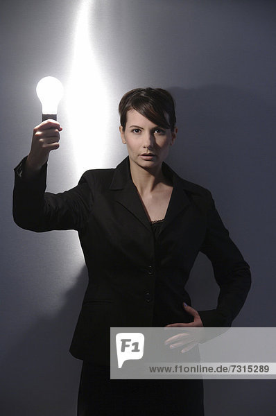 Businesswoman  aged 24  with a light-bulb in her hand