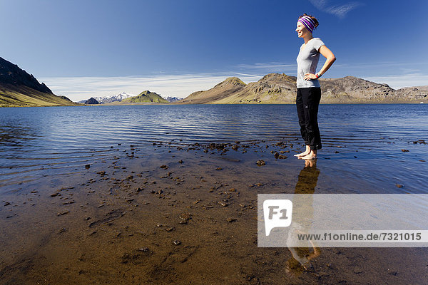 Junge Frau spiegelt sich im See Alftavatn  Island  Europa