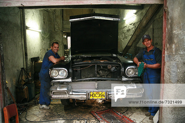 Two mechanics working in their garage  Havana  Cuba  Caribbean