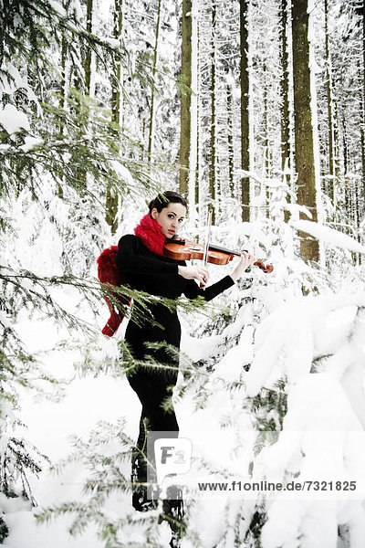 Woman  19 years  with violin in a snowy winter landscape