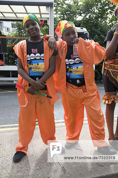 Two young boys in orange suit carnival costumes. Notting Hill Carnival. Notting Hill. London. England. UK