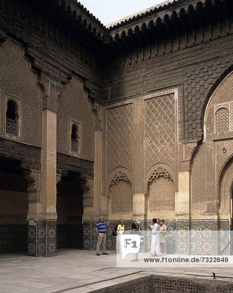 Morocco. Marrakech. Tourists in courtyard of Ali Ben Youssef Medersa.