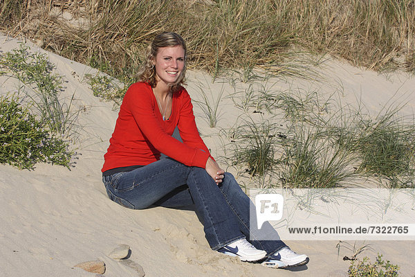 Außenaufnahme  sitzend  Frau  Strand  Sand  Düne  jung  blond  freie Natur
