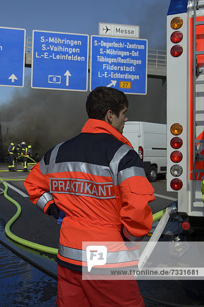 'A rescue service intern is watching a truck fire on the A8 motorway near the ''Echterdinger Ei'' junction  Stuttgart  Baden-Wuerttemberg  Germany  Europe'