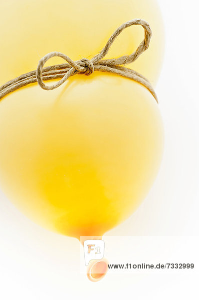 Yellow balloon with a string tied around