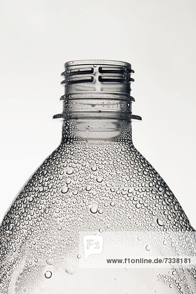 Eine Kunststoff-Wasserflasche ohne Kappe  auf der sich Kondenswasser befindet.