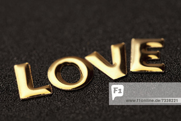 Einzelnes Wort'Liebe' in goldenem Schriftzug