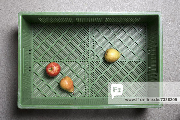 Three pieces of fruit in a plastic shopping basket