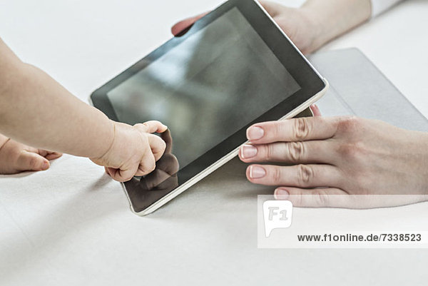 Baby zeigt auf Digitales Tablett im Besitz seiner Mutter