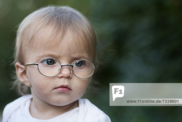 Ein junges Mädchen  das eine Brille trägt  runzelt die Stirn und schaut weg.
