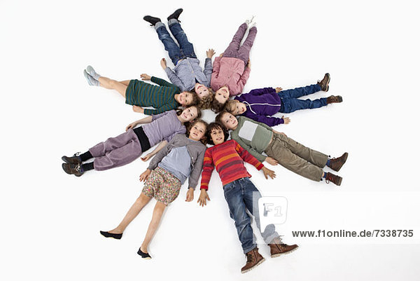 Eine Gruppe von Kindern  die im Kreis auf dem Rücken liegen.