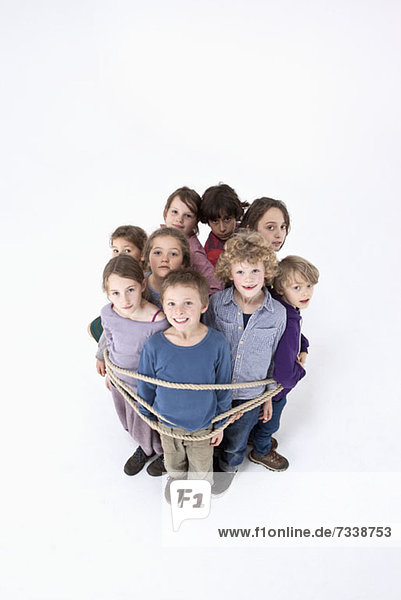 Eine Gruppe von Kindern  zusammengebunden mit einem Seil.