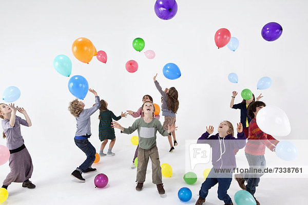 Eine Gruppe von Kindern  die mit Luftballons spielen.