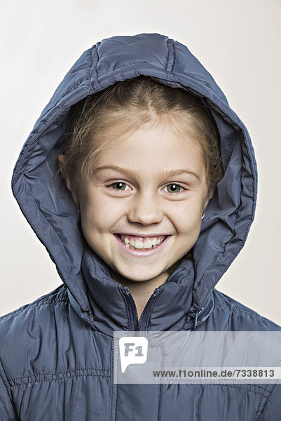 Ein fröhliches  junges Mädchen in einer Winterjacke.