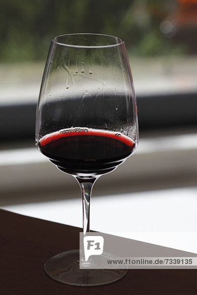 Ein Glas Rotwein mit Weinbeinen