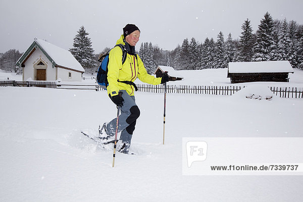 Snowshoe hiker walking on a trail to Hoher Kranzberg mountain  Mittenwald  Bavaria  Germany  Europe