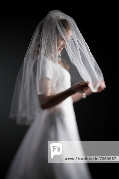 Profile of a bride holding her veil
