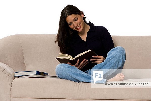 Frau sitzt auf einer Couch und ein Buch zu lesen
