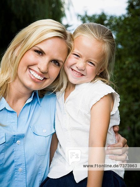 Portrait of a young woman and her daughter smiling