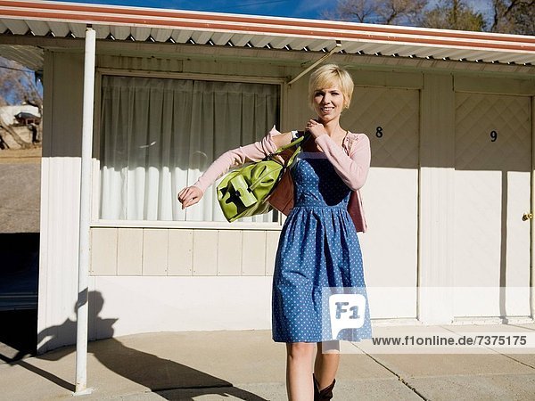 woman in front of a motel room.