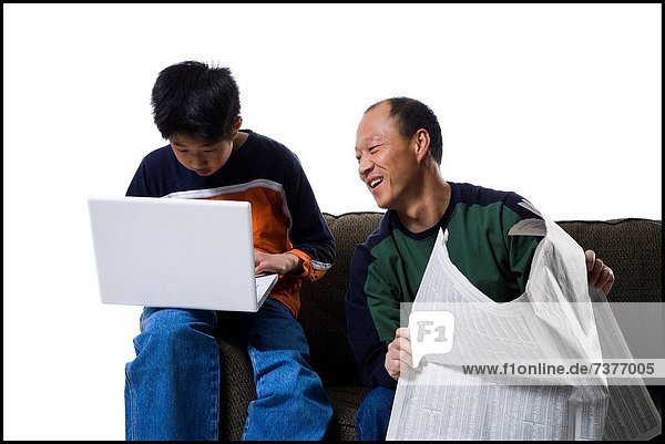 benutzen  Notebook  Menschlicher Vater  Sohn  halten  Zeitung