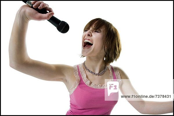 Close_up of a teenage girl singing into a microphone