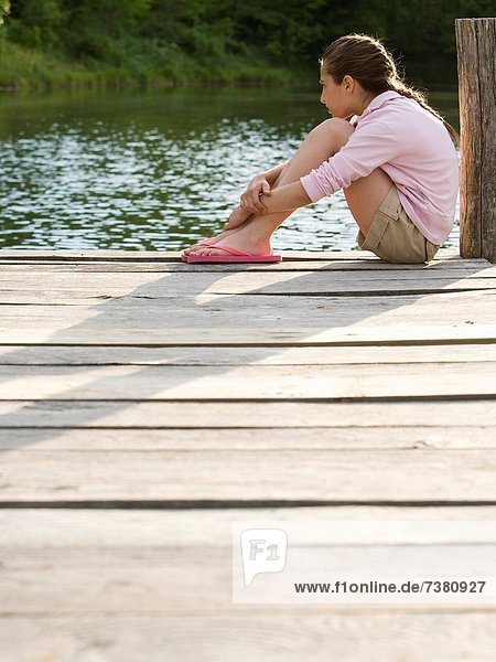Portrait of a girl sitting on a pier