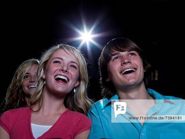 Boy and girl watching film at movie theater smiling