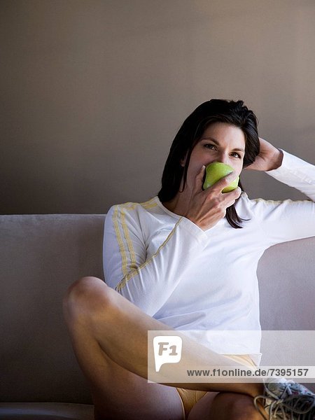 sitzend Frau Couch grün Apfel essen essend isst