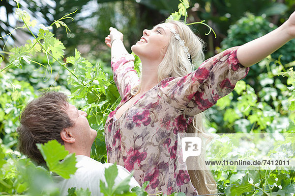 Mann mit Freundin in hohen Pflanzen