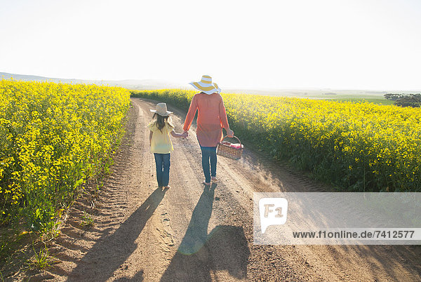 Mother and daughter walking on dirt road