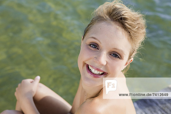 Woman smiling by still lake