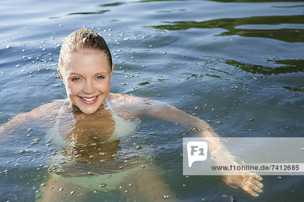 Lächelnde Frau im See schwimmend