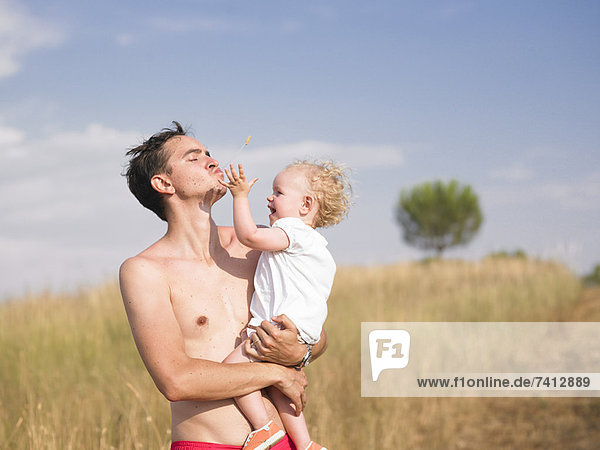 Man carrying son outdoors