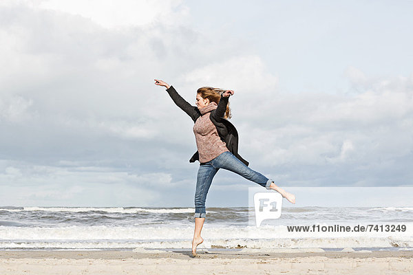 Frau springt auf den Strand