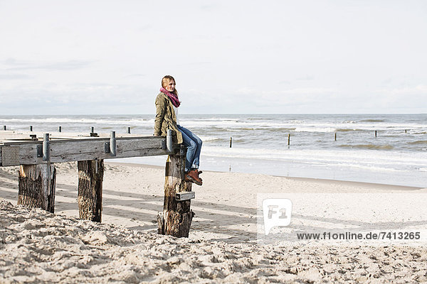 Frau am verlassenen Pier am Strand