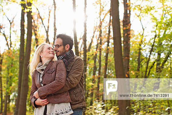 Smiling couple hugging in forest