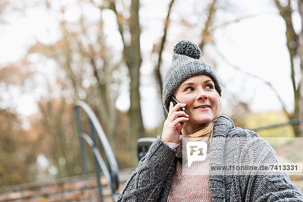 Frau spricht am Handy im Park