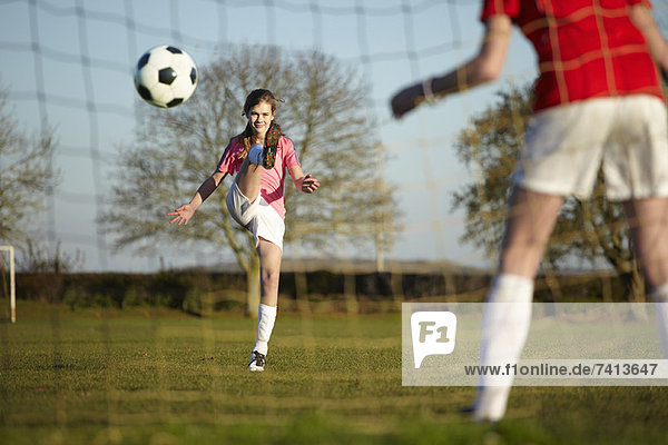Mädchen tritt Fußball ins Tor