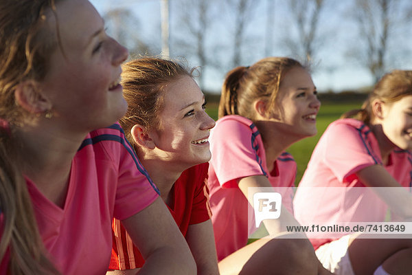 Fußballmannschaft lächelt zusammen im Feld