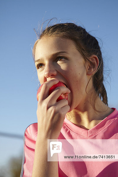 Girl eating apple outdoors